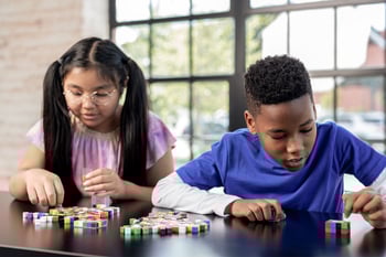 A photo of two students using unifix cubes during a Eureka Math Squared lesson. 